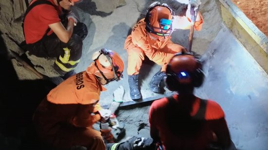 Equipe do Corpo de Bombeiros realizou o resgate do corpo, que foi "engolido" pela areia - Corpo de Bombeiros