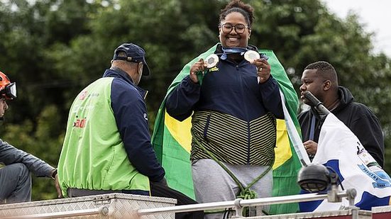 Beatriz Souza,26, judoca medalha de ouro nos Jogos Olímpicos de Paris 2024, desfila em carreata com o Corpo de Bombeiros, acompanhada do pai e do marido, pelas ruas de Peruíbe, litoral sul paulista. | Adriano Vizoni/Folhapress