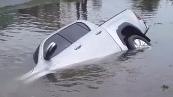 Imagem Após alagamento, motorista de caminhonete erra na curva e carro cai no córrego