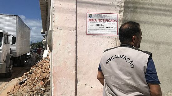 Fiscal da Semurb colando adesivo de notificação em obra irregular, no Poço | Foto: Ascom Semurb