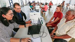 Servidora e juiz André Gêda atendem cidadãos em ação no Vergel no Lago, em Maceió | Foto: Caio Loureiro / Ascom TJ