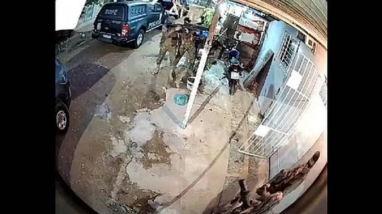 Imagem de câmera de segurança mostra momento em que policiais invadem imóvel; momentos depois, eles saem carregando um corpo em um lençol | Reprodução