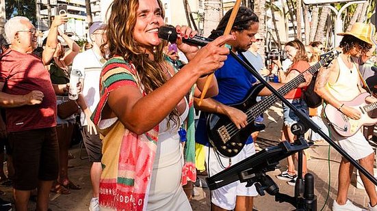 Formado por cerca de 60 membros, o grupo, liderado pela cantora Fernanda Guimarães, é conhecido por sua fusão única de clássicos do rock com a batida vibrante do maracatu | Foto: Mônica Guimarães