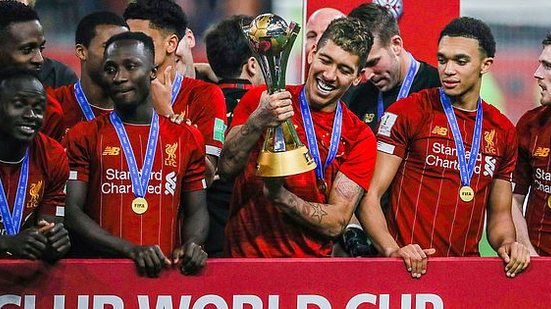 Roberto Firmino, autor do gol do Liverpool no jogo contra o Flamengo pelo Mundial de Clubes, segura a taça de campeão após a vitória na prorrogação, no Khalifa International Stadium, em Doha, no Qatar | Brazil Photo Press/Folhapress