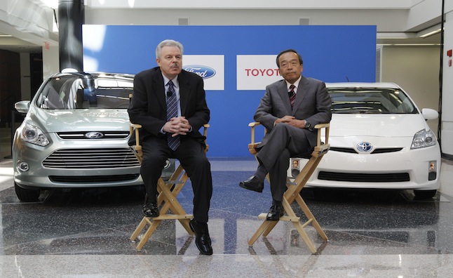 Derrick Kuzak, Ford Motor Company group vice president, Global Product Development, left, and Takeshi Uchiyamada, Toyota Motor Corporation executive vice president, Research & Development shake hands at a news conference in Dearborn, Mich., Monday, Aug. 22, 2011. The automakers announced they will equally collaborate on the development of an advanced new hybrid System for light truck and SUV customers. (AP Photo/Paul Sancya)