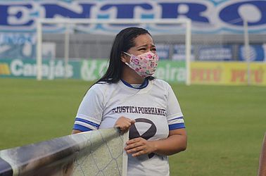 Tia de Rhaniel segura uma faixa antes da partida